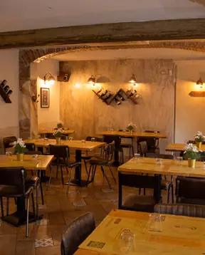 La sala a pranzo, con i tavoli apparecchiati sotto gli archi